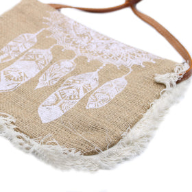 bolso con flecos blancos y un dibujo de atrapasueños con plumas en blanco